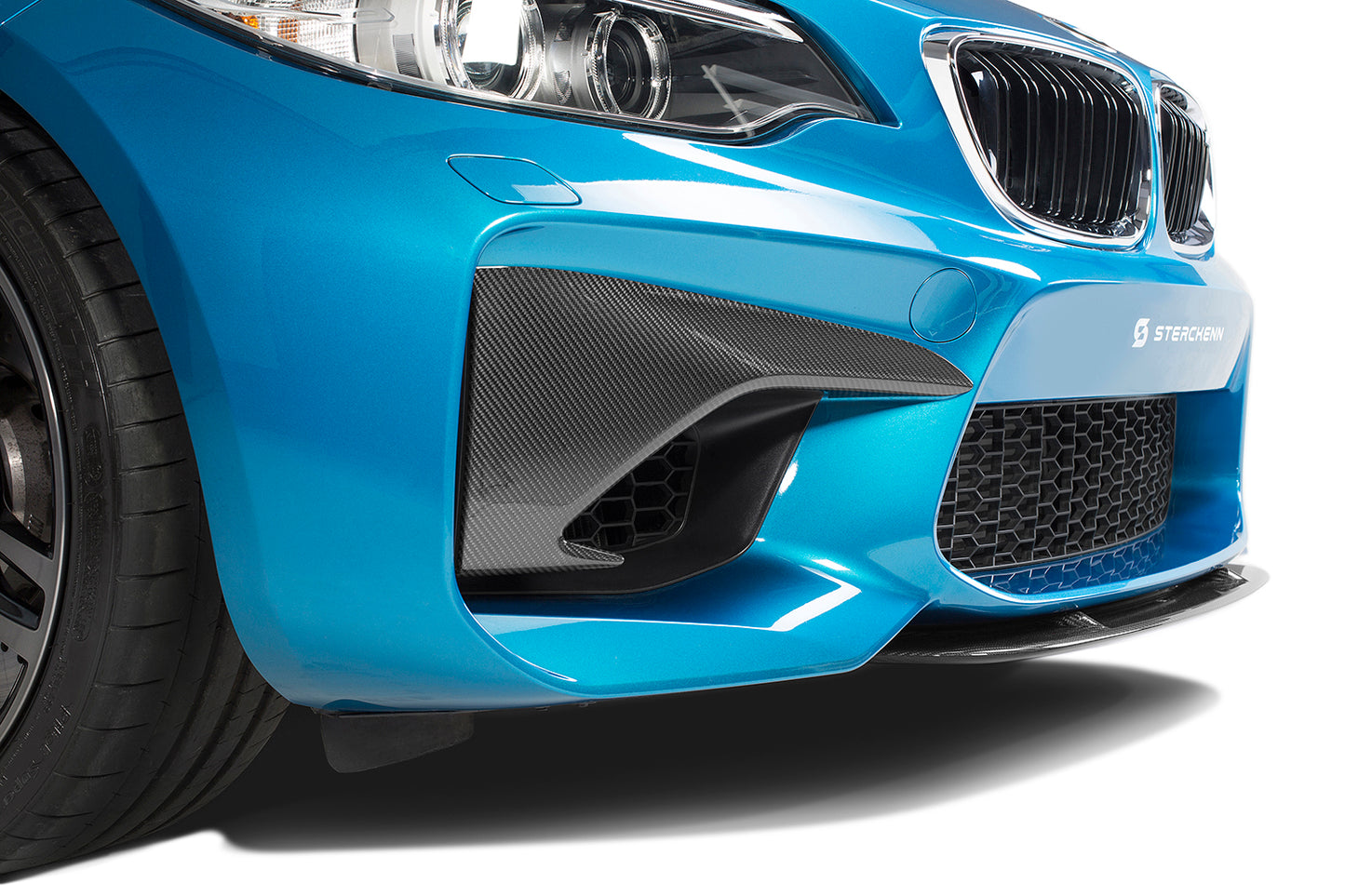 The front bumper of the blue bmw M2 (F87) on a white background