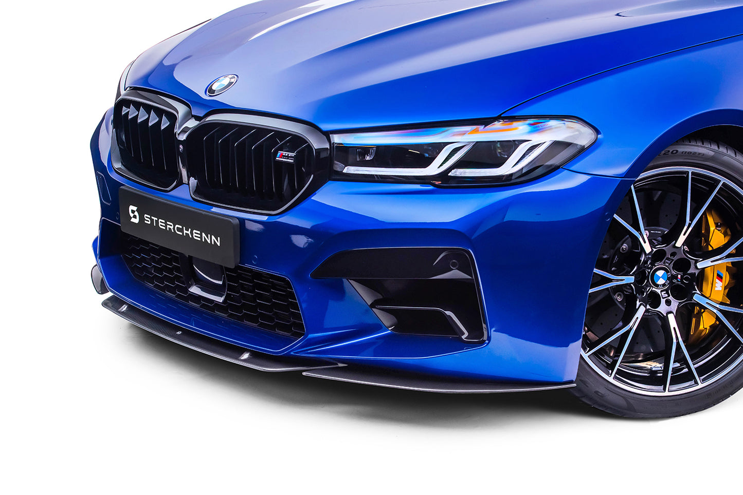 The bumper of a blue BMW M5 (F90) LCI with the splitter