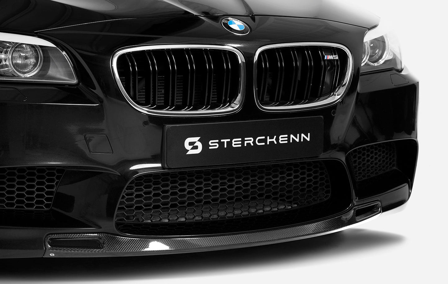 Front bumper with splitter of black BMW M5 (F10) with Sterckenn logo