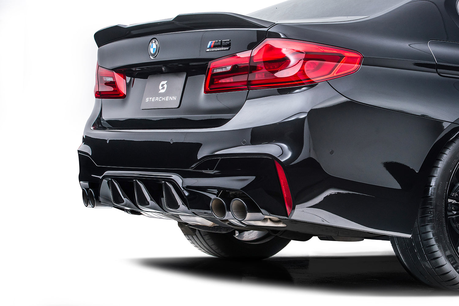 Rear bumper with diffuser in black BMW M5 (F90) on a white background