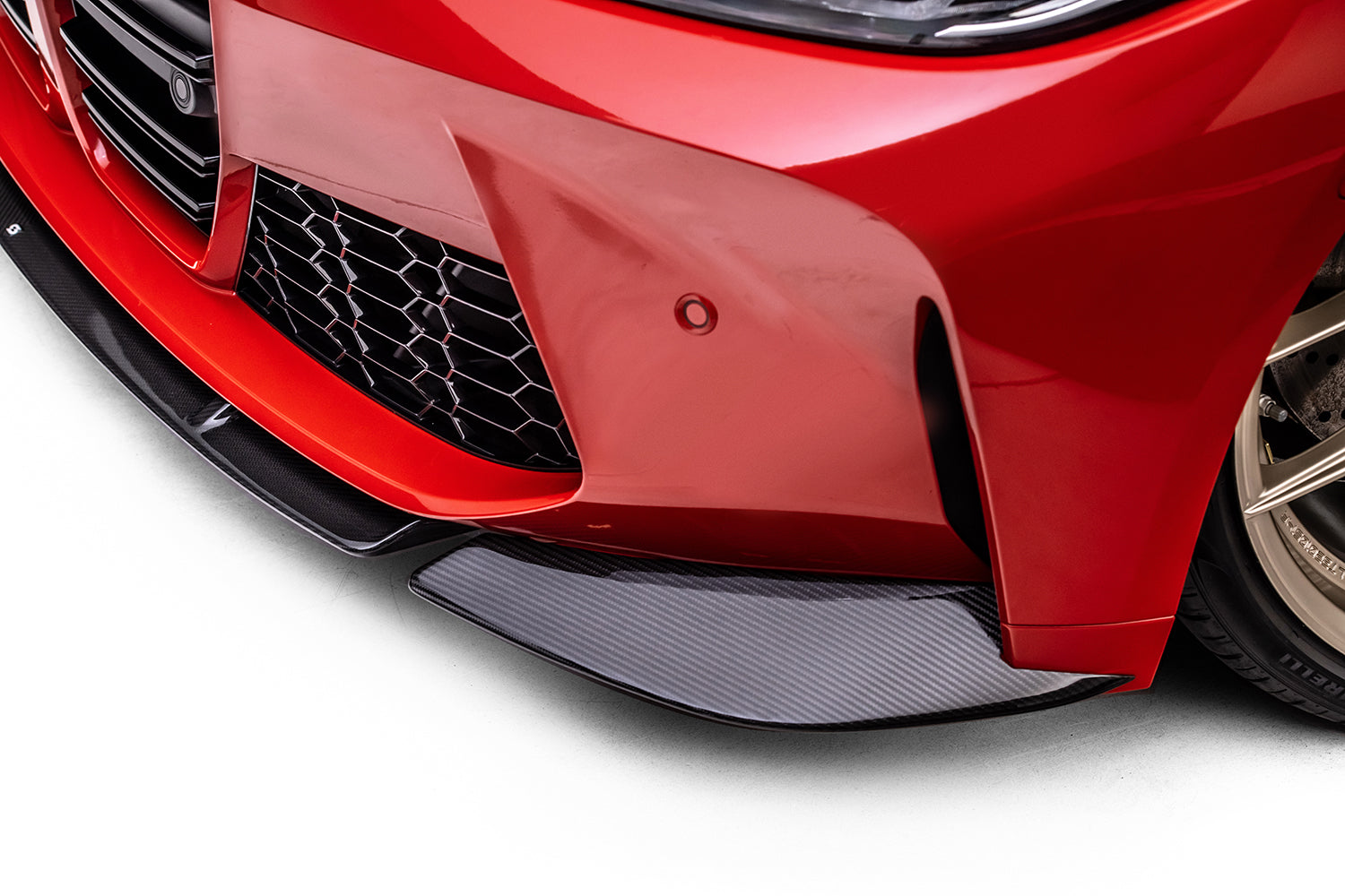 front of red bmw with black splitter on white background