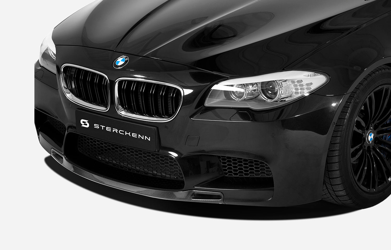 Front bumper with splitter of black BMW M5 (F10) on a white background