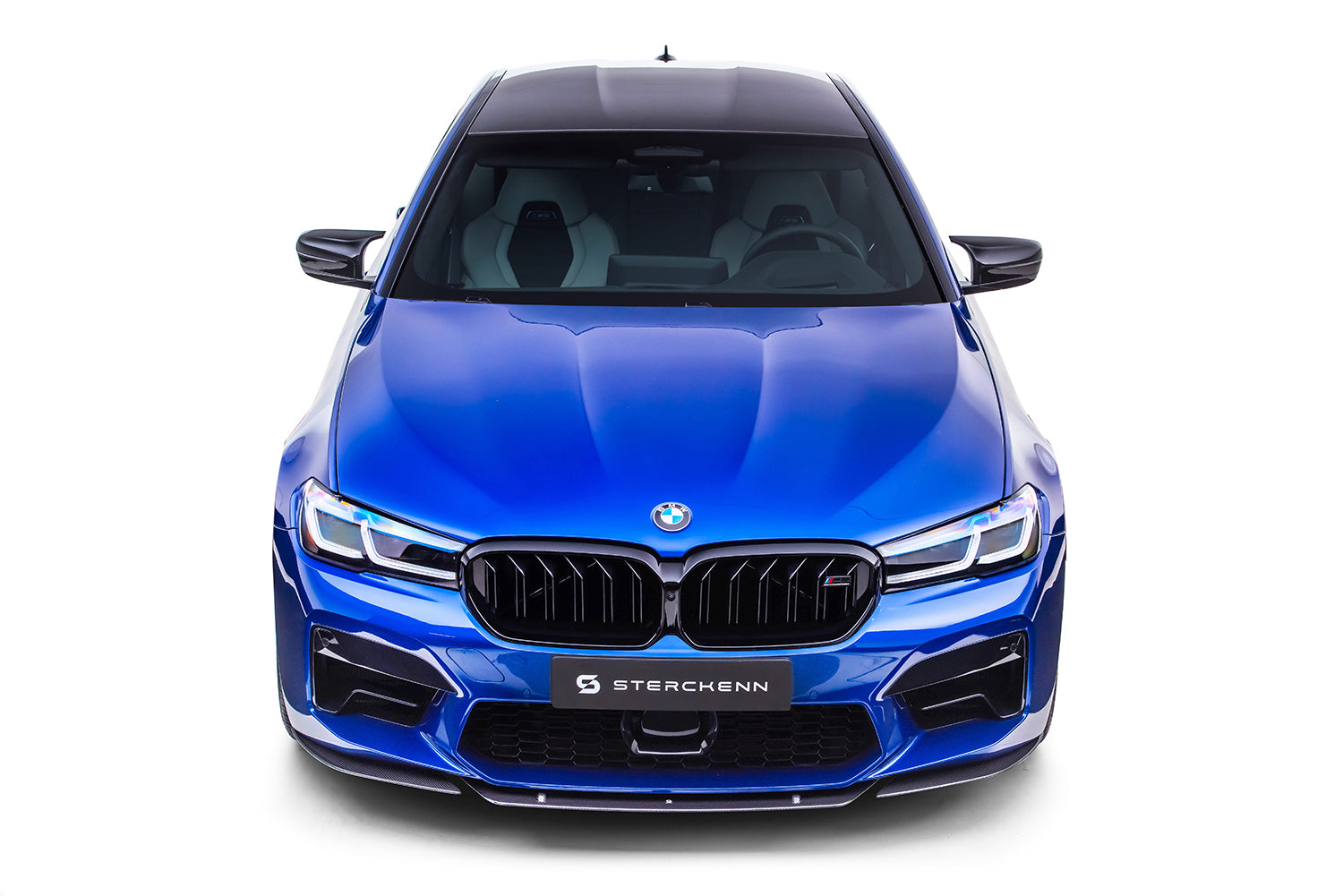 Front view of a blue BMW M5 (F90) LCI on a white background
