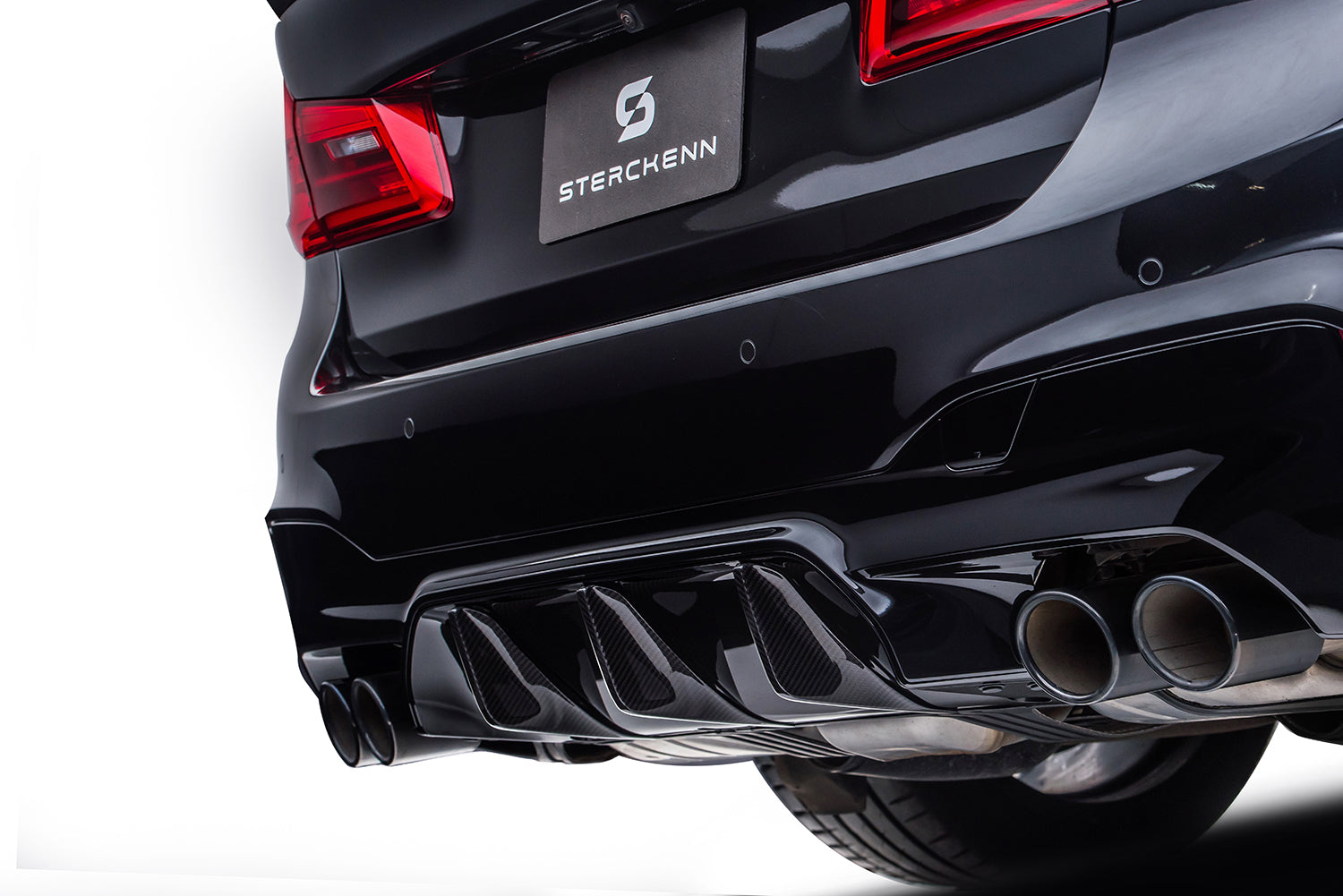 Close-up of the rear bumper of a black BMW on a white background