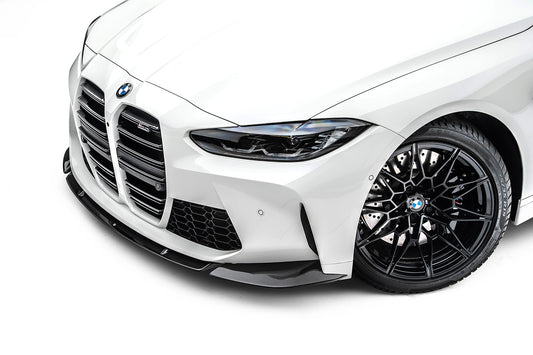 The front bumper of a white BMW M4 (G82) on a white background
