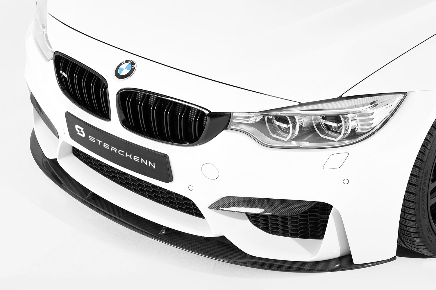 side view of white bmw with sterckenn logo